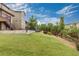 Backyard featuring lush green lawn, a charming wooden fence, and a set of stairs at 18815 W 93Rd Ave, Arvada, CO 80007