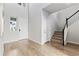 Bright entryway with wood floors, a white staircase, and ample natural light from a window at 18815 W 93Rd Ave, Arvada, CO 80007