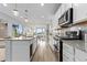 Open kitchen showcases stainless steel appliances, granite countertops, and an island with bar seating at 18815 W 93Rd Ave, Arvada, CO 80007
