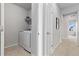 Hallway laundry room featuring white front-loading machines and built-in shelving at 18815 W 93Rd Ave, Arvada, CO 80007