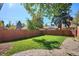 Spacious backyard featuring a green lawn, bordered by a wooden fence and mature trees providing ample shade at 1275 Birch St, Denver, CO 80220