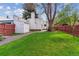 Spacious backyard with a large lawn, mature trees, and a storage shed at 1275 Birch St, Denver, CO 80220
