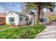 Charming home with a lush front yard, brick walkway and white painted brick at 1275 Birch St, Denver, CO 80220