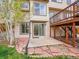 Backyard view featuring a patio, wooden deck with stairs, and a well-manicured lawn at 6343 Laguna Cir, Highlands Ranch, CO 80130
