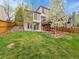 Spacious backyard with green lawn, patio, and wood deck, perfect for outdoor entertaining at 6343 Laguna Cir, Highlands Ranch, CO 80130