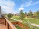 The backyard view features a large grassy common area, walking path, and mature trees at 6343 Laguna Cir, Highlands Ranch, CO 80130
