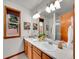 Well-lit bathroom featuring double sinks, and framed mirrors at 6343 Laguna Cir, Highlands Ranch, CO 80130