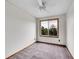 An empty bedroom with gray carpet, a ceiling fan, and a window overlooking trees at 6343 Laguna Cir, Highlands Ranch, CO 80130