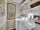 Bright laundry room with washer, dryer, shelves, and window allowing for natural light at 6343 Laguna Cir, Highlands Ranch, CO 80130