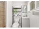 Clean and compact bathroom with a modern vanity, toilet, and shelving unit, maximizing space at 4450 S Fox St, Englewood, CO 80110