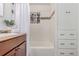 Bathroom with a shower-tub combo with tile surround and a decorative stain glass window feature at 4450 S Fox St, Englewood, CO 80110
