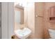 Compact bathroom with a sink and decorative wallpaper at 1283 W 112Th Ave # B, Denver, CO 80234