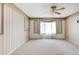 Bedroom features neutral carpeting, a ceiling fan, and a large window for natural light at 1283 W 112Th Ave # B, Denver, CO 80234