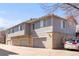 Exterior view of a townhome featuring garage doors and brick accents at 1283 W 112Th Ave # B, Denver, CO 80234