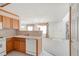 Well-lit kitchen with wood cabinets and a view into the living room at 1283 W 112Th Ave # B, Denver, CO 80234