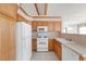 Functional kitchen featuring white appliances, wood cabinets, and tiled flooring at 1283 W 112Th Ave # B, Denver, CO 80234