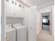 Functional laundry room featuring white washer, dryer, and storage cabinets at 1283 W 112Th Ave # B, Denver, CO 80234