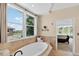 Bright bathroom features a soaking tub with view to the yard and a connected bedroom at 11208 W Ontario Ave, Littleton, CO 80127