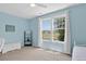Bright bedroom features large windows with picturesque views, ceiling fan, and neutral carpet at 11208 W Ontario Ave, Littleton, CO 80127