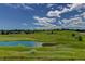 Expansive golf course view with lush greenery, a tranquil pond, and a neighborhood of beautiful homes in the background at 11208 W Ontario Ave, Littleton, CO 80127