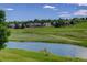 Scenic view of a pond and golf course with well-manicured greens, surrounded by lovely homes at 11208 W Ontario Ave, Littleton, CO 80127