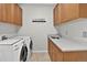Convenient laundry room with sink, cabinets, and modern washer and dryer at 11208 W Ontario Ave, Littleton, CO 80127