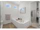 Bright bathroom featuring a soaking tub, dual windows, and tile floors at 8023 Gore Creek Ln, Littleton, CO 80125