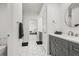 Modern bathroom featuring a white vanity, a shower with black tile, and grey cabinets at 8023 Gore Creek Ln, Littleton, CO 80125