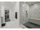 Modern bathroom with glass shower, white hexagon tile, and doorway views of a gym and bedroom at 8023 Gore Creek Ln, Littleton, CO 80125