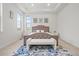 Bright bedroom featuring large windows, a tufted headboard, and a comfortable seating area at 8023 Gore Creek Ln, Littleton, CO 80125