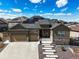 Charming home with a stone-accented facade, three-car garage, concrete driveway and solar panels at 8023 Gore Creek Ln, Littleton, CO 80125