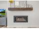 Elegant fireplace with a wooden mantle and modern glass encased firebox at 8023 Gore Creek Ln, Littleton, CO 80125