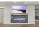 Modern electric fireplace with marble detail and a large screen television mounted above, perfect for cozy evenings at 8023 Gore Creek Ln, Littleton, CO 80125