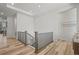 Bright hallway with modern wood-style floors, black metal railings and abundant natural light at 8023 Gore Creek Ln, Littleton, CO 80125