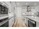 Open-concept kitchen with stainless steel appliances, white cabinets, and island seating at 8023 Gore Creek Ln, Littleton, CO 80125