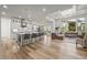 Open floor plan with a modern kitchen, oversized island, and a sun-filled living room at 8023 Gore Creek Ln, Littleton, CO 80125