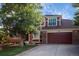 Brick home with a two-car garage and manicured lawn at 8631 Gladiola Cir, Arvada, CO 80005