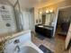 This primary bathroom features a tub, glass shower, and vanity with solid surface countertops at 13660 Monroe St, Thornton, CO 80602