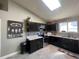 Modern kitchen featuring dark cabinetry, stainless steel appliances, and ample counter space at 13660 Monroe St, Thornton, CO 80602