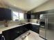 Modern kitchen featuring dark cabinetry, stainless steel appliances, and ample counter space at 13660 Monroe St, Thornton, CO 80602