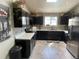 Modern kitchen featuring dark cabinetry, stainless steel appliances, and ample counter space at 13660 Monroe St, Thornton, CO 80602