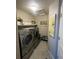 Well-organized laundry area featuring modern washer and dryer, shelving, and decorative accents at 13660 Monroe St, Thornton, CO 80602