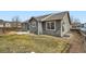 Exterior view of backyard with grassy lawn, gravel area, partial fence, and gray siding at 261 Hermosa St, Brighton, CO 80603