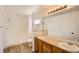 Bright bathroom with a double sink vanity, framed mirror, a shower over bath, and wood-look flooring at 261 Hermosa St, Brighton, CO 80603