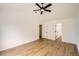 Spacious bedroom featuring new wood-look flooring, white walls, ceiling fan, and two entry doors at 261 Hermosa St, Brighton, CO 80603