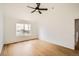 Bright, open bedroom featuring hardwood floors, a ceiling fan, and a large window at 261 Hermosa St, Brighton, CO 80603