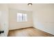 Bedroom featuring wood-look flooring, white walls, and a window with a view of the outdoors at 261 Hermosa St, Brighton, CO 80603