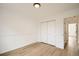 Cozy bedroom with wood-look flooring, white walls, and a closet with bi-fold doors at 261 Hermosa St, Brighton, CO 80603