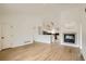 Bright living area featuring wood floors and fireplace, leading to a modern kitchen at 261 Hermosa St, Brighton, CO 80603