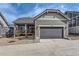 Home exterior with gray siding, a garage, and stone landscaping at 1104 Brocade Dr, Littleton, CO 80126
